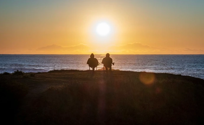 Moment de contemplation face à l'océan Atlantique pour symboliser le retour à soi après un stage de survie en Bretagne.